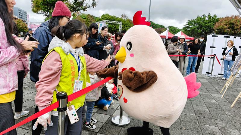 家樂福人氣玩偶「快樂雞」為健走民眾加油打氣。
