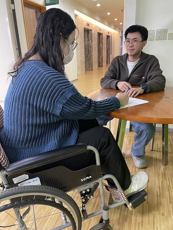 社工協助至社會處的民眾填寫緊急救援服務申請表。