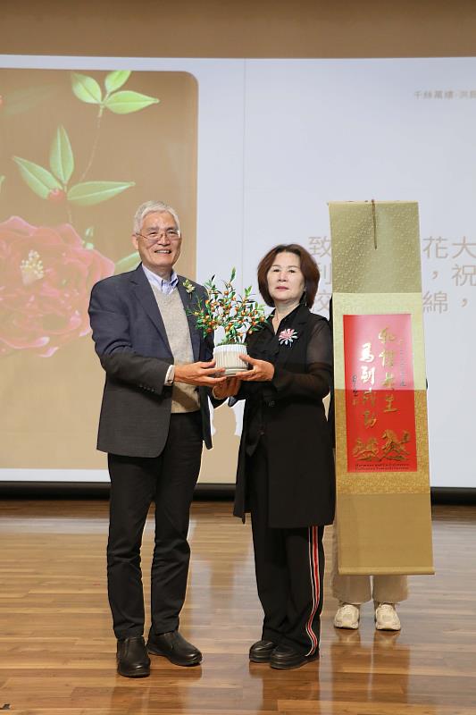 南華大學樂齡學員洪銀霜(右)辦春仔花創作展,並致贈以春仔花工藝製作的金桔樹給高俊雄校長(左)。