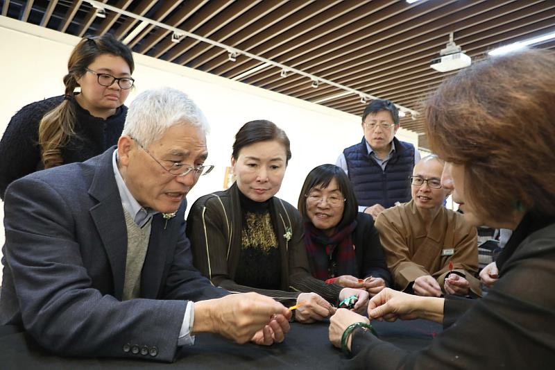 南華大學樂齡學員洪銀霜(右)辦春仔花創作展,邀請高俊雄校長(左1)、賴淑玲副校長(左2)及師長們體驗製作春仔花。