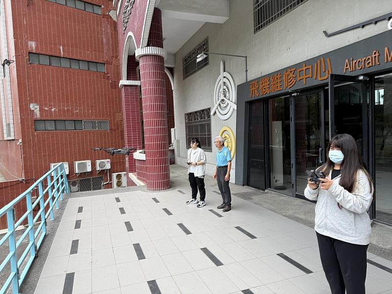社團指導老師張偉國（中）指導社團學生林沛慈（左）、蔡沛臻（右）操作無人機。（圖/ 中信科大提供）