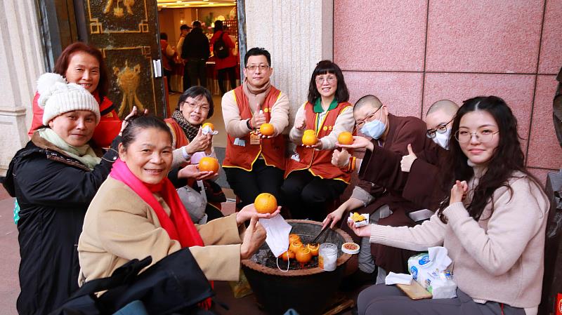 與法師圍爐烤橘子、話家常，是靈鷲山獨有的暖心年味活動。（圖由靈鷲山佛教教團提供）