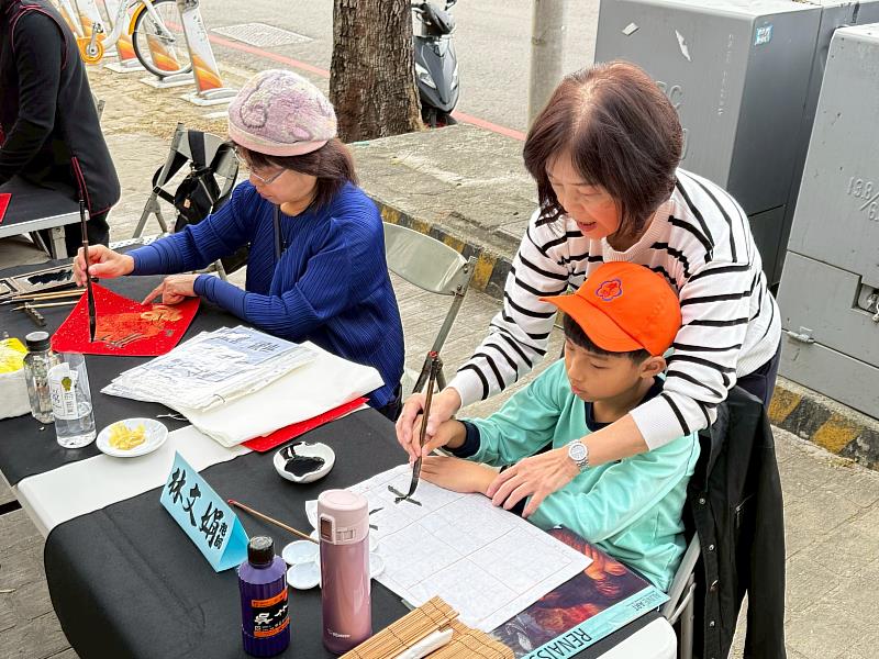 書藝精湛的書法老師與學童現場揮毫寫書法。