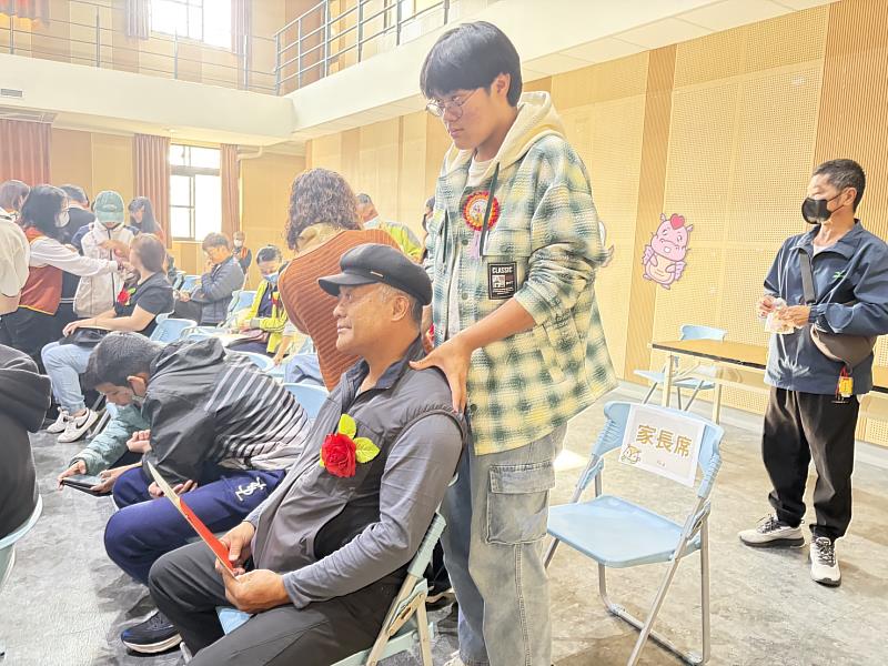 靈鷲山台東普仁獎頒獎典禮上，小太陽為家長按摩，感謝家長無私奉獻，場面溫馨感人。（圖由靈鷲山佛教教團提供）