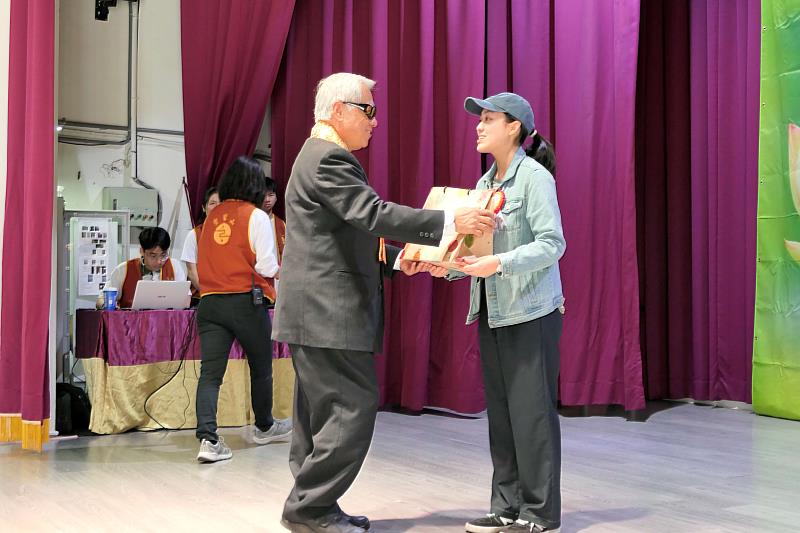 台東縣前縣長陳建年（左）致贈禮物給豐田國中曾介卉。（圖由靈鷲山佛教教團提供）