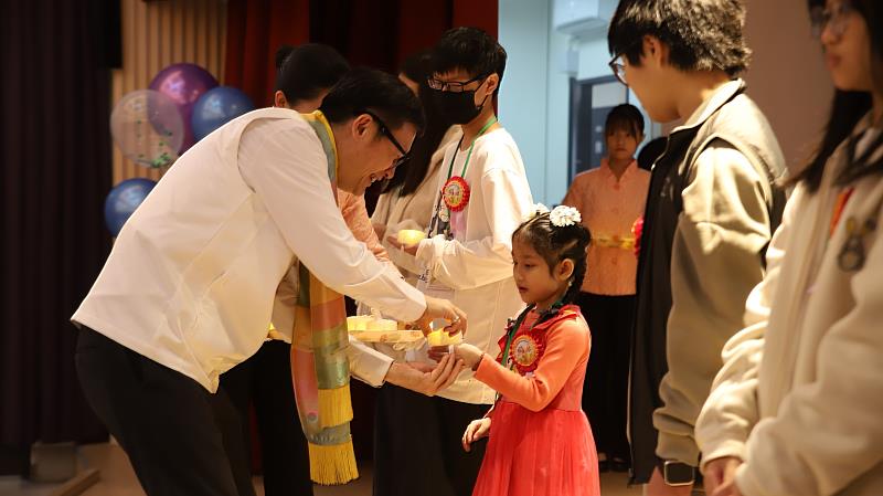 張明文局長為得獎的小太陽戴上「五德之星」，讓生命的光芒照亮全場。（靈鷲山佛教教團提供）