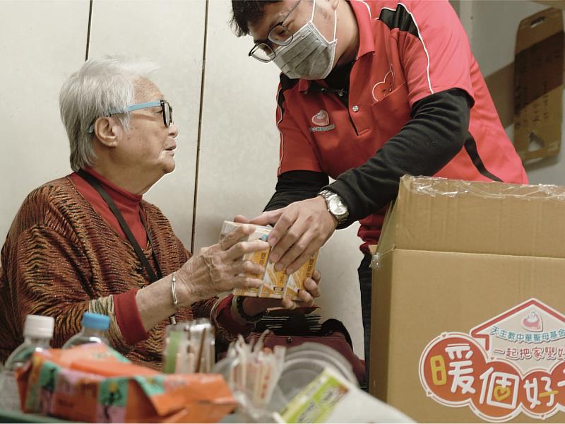 基金會社工耐心地為春枝阿嬤介紹箱內物資，包含調理包、牛奶等，阿嬤透過雙手細細摸索形狀，確保自己能了解每一樣暖心餐點。
