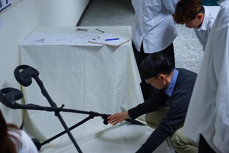 林萱教授與胡丞耀同學組別討論新型地膜機的操作。