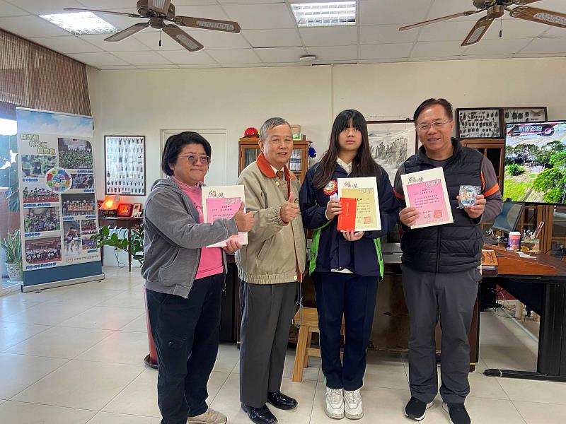 1. 普仁新竹區會長高傳鑑（左）到新湖國中，在學校師長陪同下，頒獎給得獎小太陽陳邑柔（中）。（靈鷲山佛教教團提供）