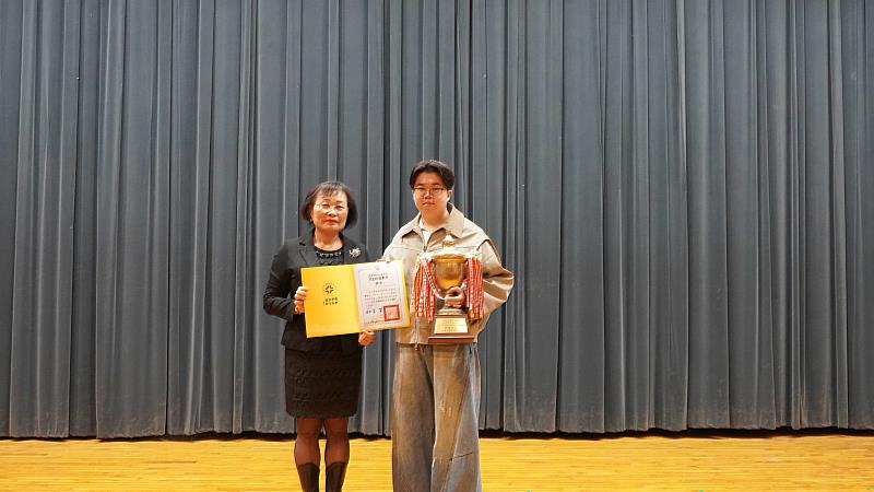 時尚造型設計系黃冠中同學（右）參加第73回日本藝術祭國際競賽「長髮包頭造型組」中榮獲冠軍，並獲頒「古董獎盃」。