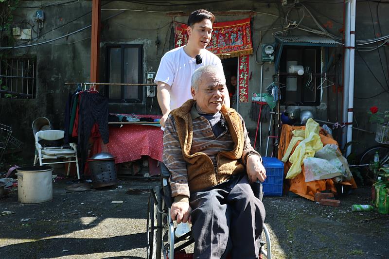 無尊推著潘伯伯到戶外曬太陽，完成70歲的生日願望。