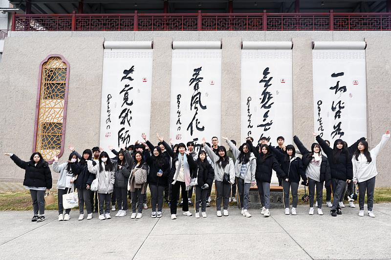 南華大學舉辦校園走讀活動，高中生在創辦人星雲大師一筆字牆前合影留念。