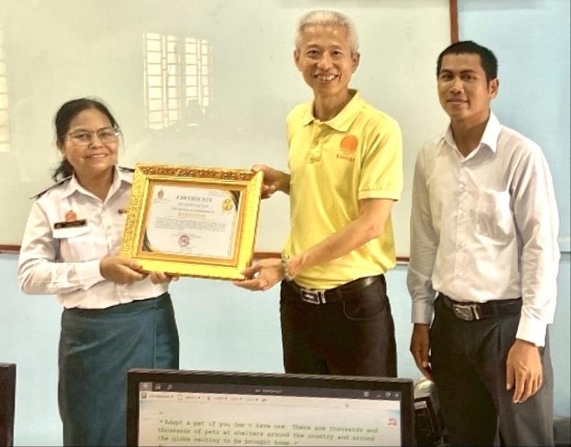 受助學校Hun Sen Phnom Sruoch High School校長（左），傑出校友李政鍠博士（中）代表暨大，於該校致贈感謝狀儀式中合影。