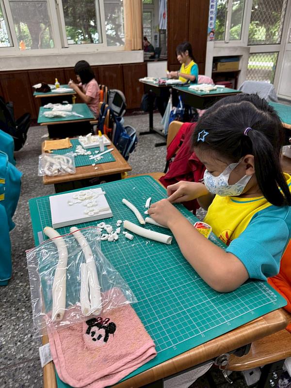 學童切割蓪草。