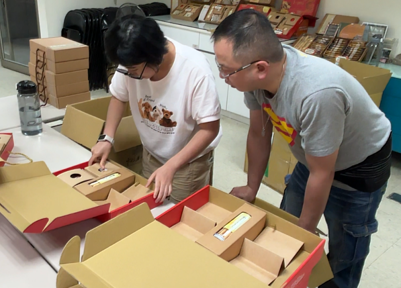 世界幫扶協會教導身心障礙者组裝禮盒。