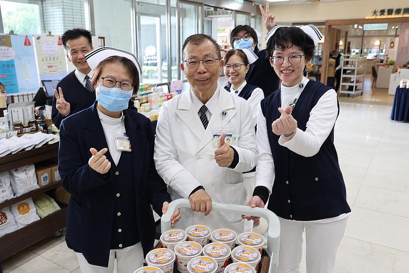 副院長吳彬安（中）將熱騰騰的臘八粥送到民眾手中，與大家分享佛陀成道的喜悅。左為護理部督導張智容，右為督導蘇芬蘭。