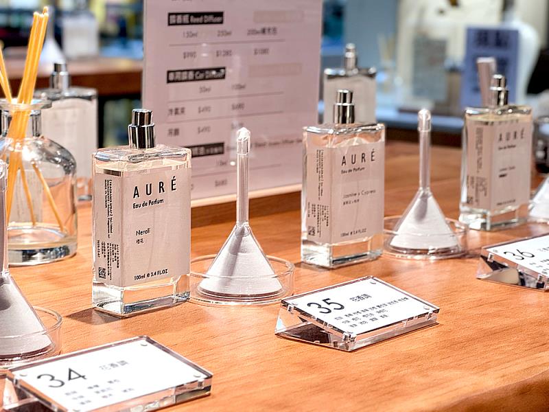 櫃位桌面陳列多款香氛試聞樣品，搭配清楚的配方說明桌牌，引導觀眾從氣味、原料到調性，理解香氛與空間氛圍之間的關係。