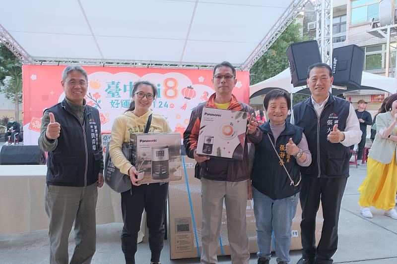 摸彩中獎民眾（左2、左3）開心與副秘書長張大春（右1）及議員張瀞分（右2）合影。