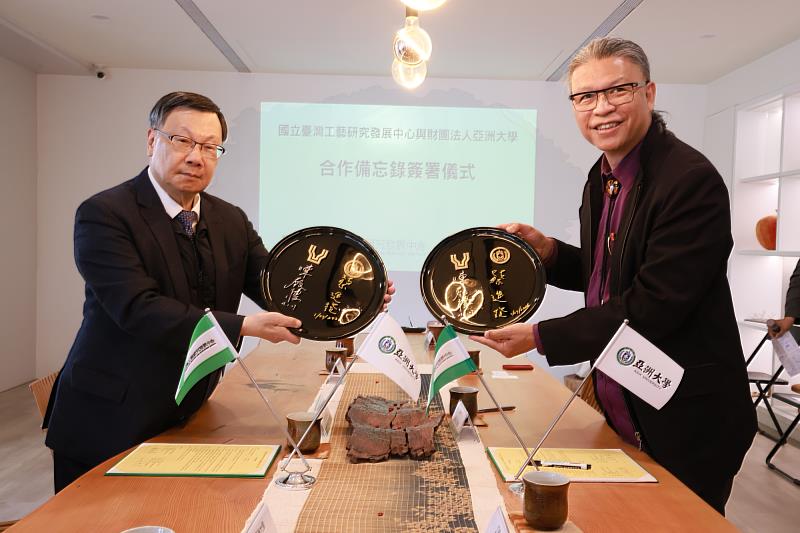 亞洲大學蔡進發校長(左)與工藝中心陳殿禮主任共同於漆盤上簽署合作備忘錄。