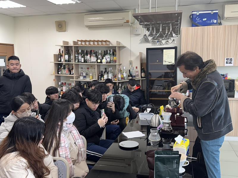 蔡俊杰老師（右）教導學員如何沖泡手沖咖啡，學員專注聆聽並錄影記錄沖泡手法。