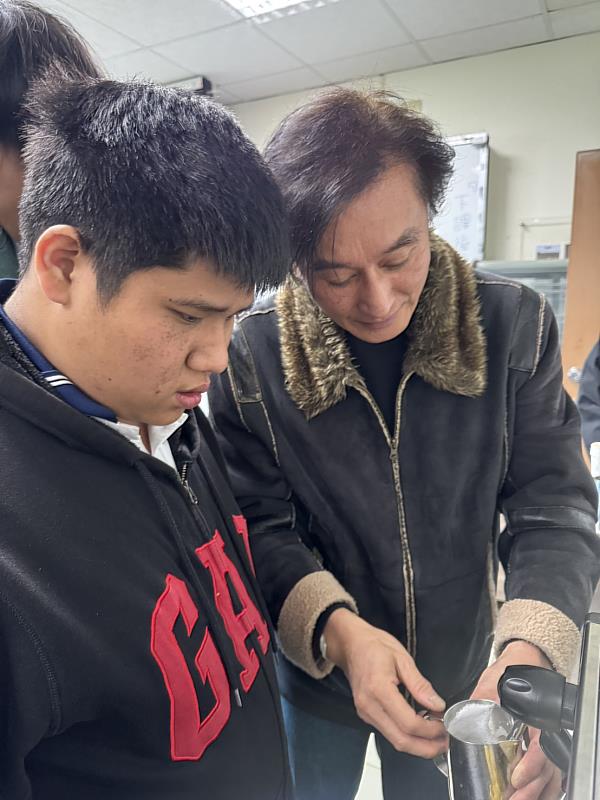 蔡俊杰老師(右)手把手教導學員如何打奶泡。