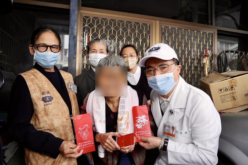 花蓮慈院林欣榮院長（白袍白帽）與顏靜曦師姊（後排灰衣）為阿公阿嬤送上證嚴上人的祝福紅包，以及新年物資。
