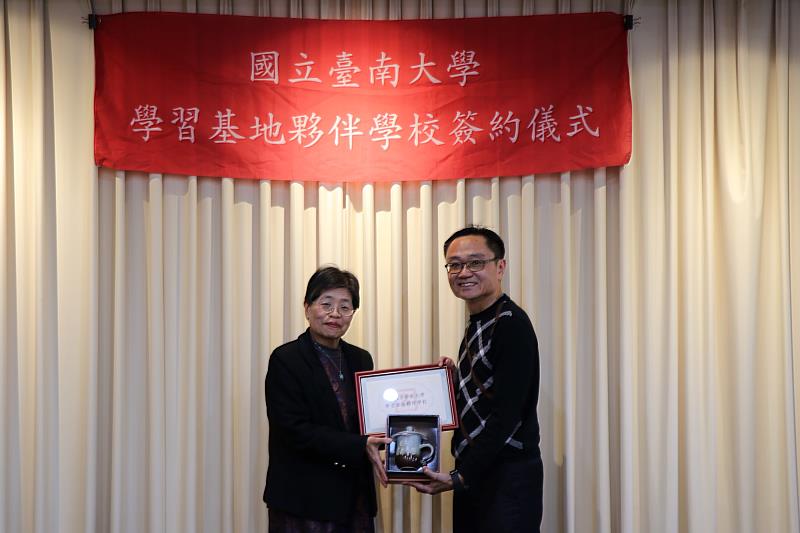 南大陳惠萍校長致贈校方紀念品予臺南市安定區安定國民小學陳伯照校長,深化大學與國小之間的教育交流。