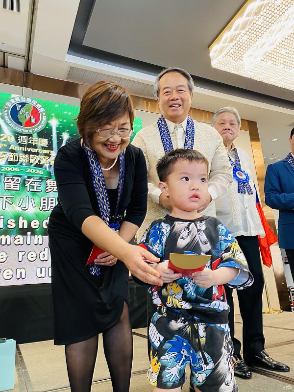 徐佳青與駐菲律賓代表處大使周民淦發送紅包予小朋友，象徵對僑界下一代的祝福與關懷。
