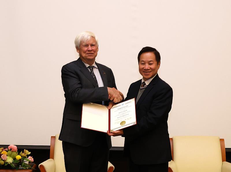 張國恩校長親頒榮譽教授聘書及琉璃教堂紀念品予Engle教授，並表示大學應成為連結學術與實務、引領理性討論的關鍵角色。
