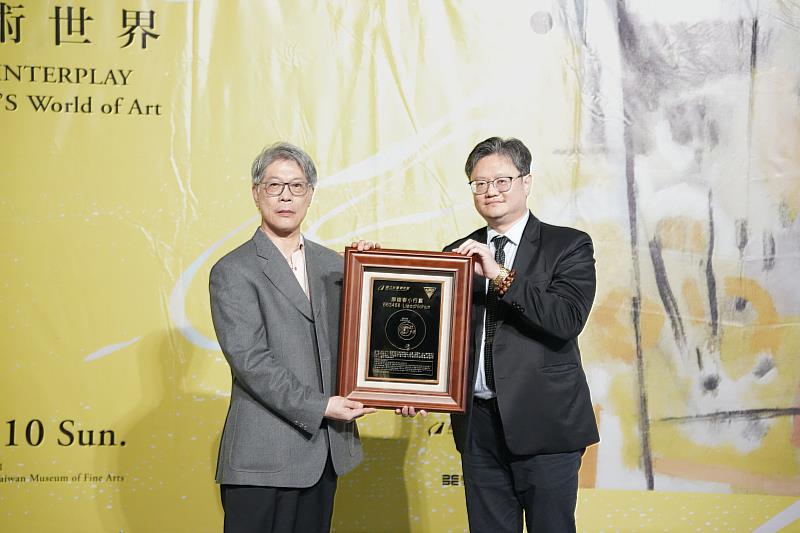 國立中央大學主任秘書李宇翔(右)致贈小行星銘版給廖繼春的家屬代表廖和恩先生(左)。