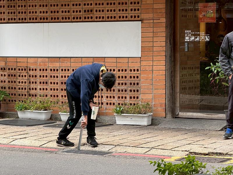 學生於東門城周邊撿菸蒂。