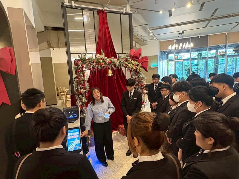 師生至福爾摩沙遊艇酒店參訪,飯店主管介紹送餐機器人。