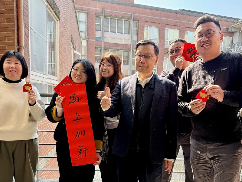 亞大教職員拿出「馬上加薪」紅字，校長笑著回應，亞大福利好，是幸福大學。