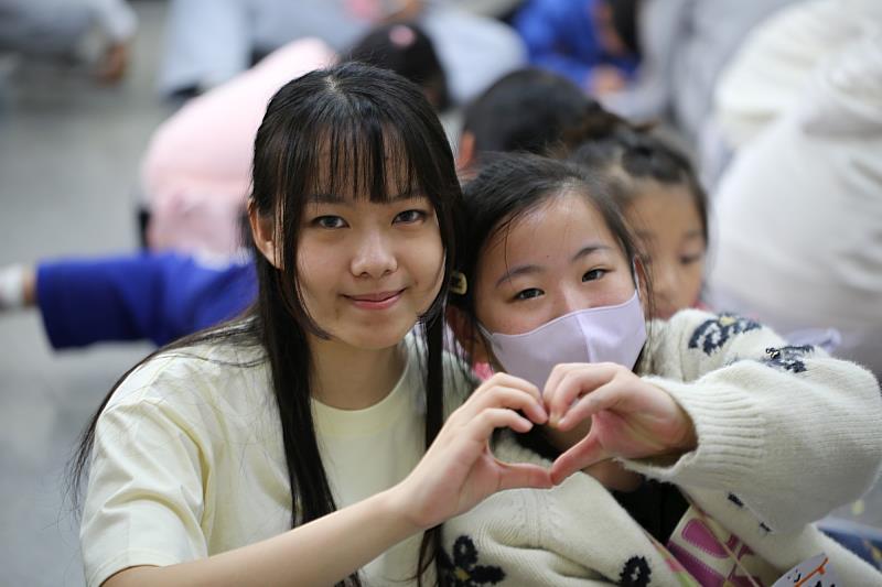 大姊姊陪學童一同玩樂。