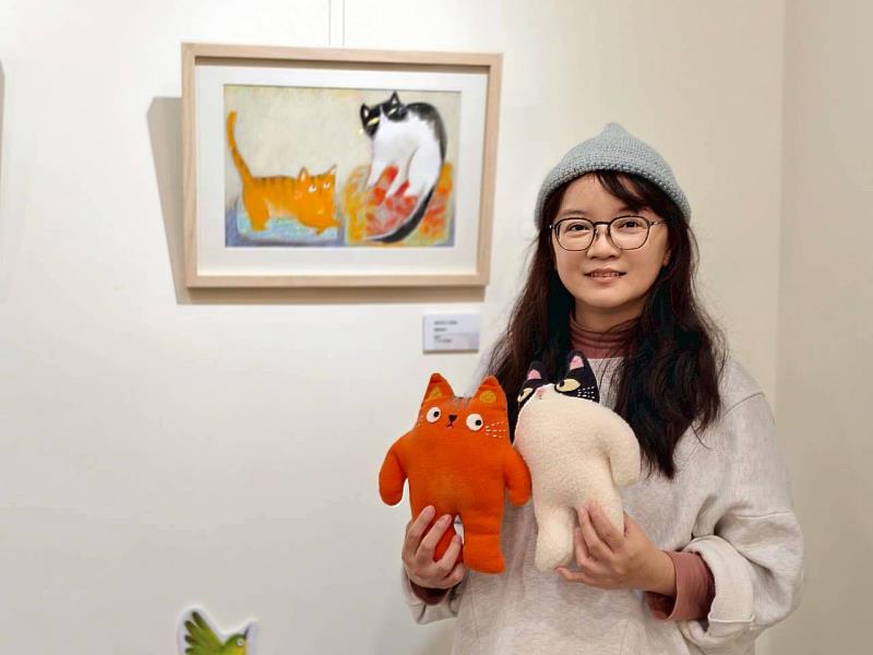 繪本作家葉曼玲與其新書《新來的小怪物》主角飯糰與橘子布偶合影。