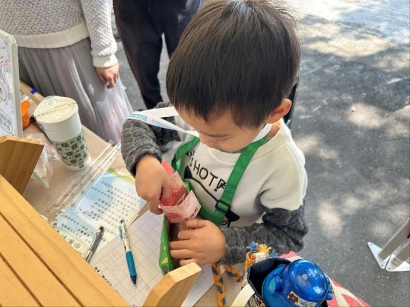 尤努斯小老闆學習自己找錢和記帳。