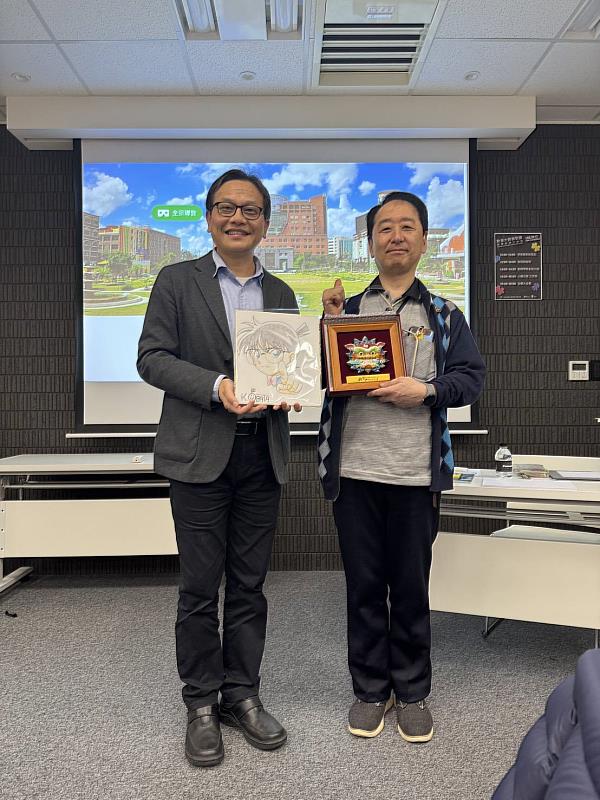 小幡公春老師（右）致贈畫作予鐘俊顏副校長（左），鐘俊顏副校長並回贈安平劍獅。