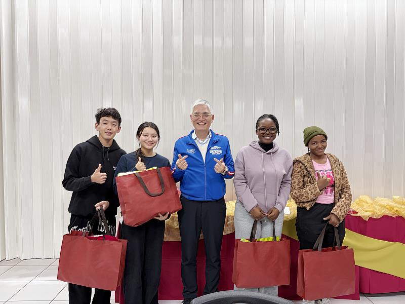 南華大學舉辦境外生歲末團圓宴，歡喜迎新春。高俊雄校長(中)發送福袋給國際生。