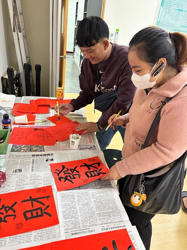 移工在新春同樂宣導活動中聚精會神寫春聯。