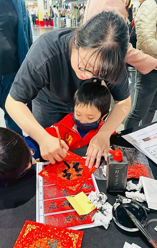 長榮大學書畫藝術學系同學引導小朋友體驗春聯書寫樂趣。