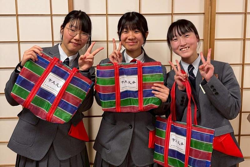 日方學生手持臺灣茄芷袋開心合影，透過南大帶來的臺灣文化元素，拉近彼此距離。