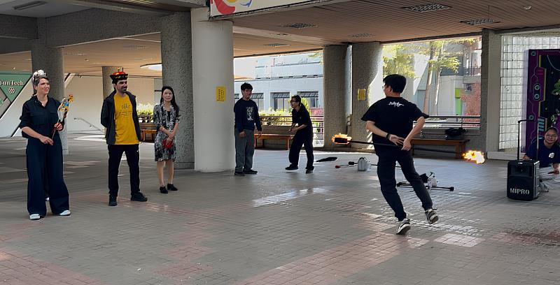 國際學生專注觀賞學生社團的火舞表演，感受熱力十足的節慶活力。