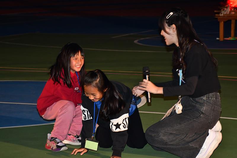 南大隊輔與孩子於燈火晚會共同演出，展現營隊期間累積的自信與表達成果。