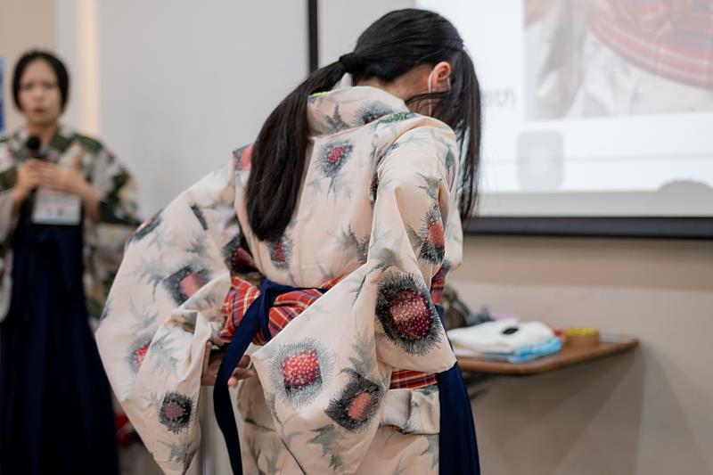 世新大學和服研究社社員為高中生介紹和服穿著技巧。（世新大學提供）