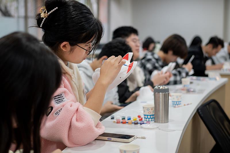 世新大學日文系寒假營隊學員投入繪製個人化的狐狸面具。（世新大學提供）