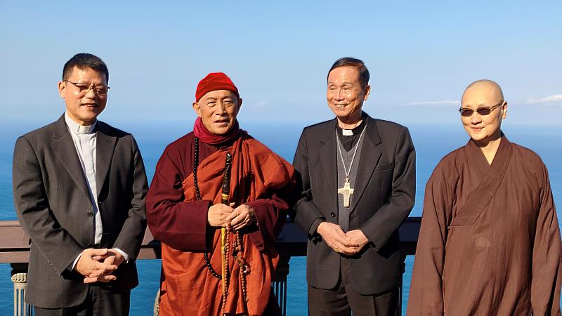 林之鼎神父（左1）、心道法師（左2）、鍾安住總主教（右2）、世界宗教博物館發展基金會執行長顯月法師（右1）於靈鷲山無生道場壯闊山海間互動交流。（圖由靈鷲山佛教教團提供）