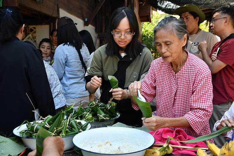 南華大學學生至泰國海外學習，推動永續與地方創生，體驗社區慢食，學習製作香蕉糯米粽。