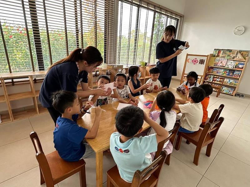 林巧庭（左）與江亮均（右）指導幼兒製作窗花。