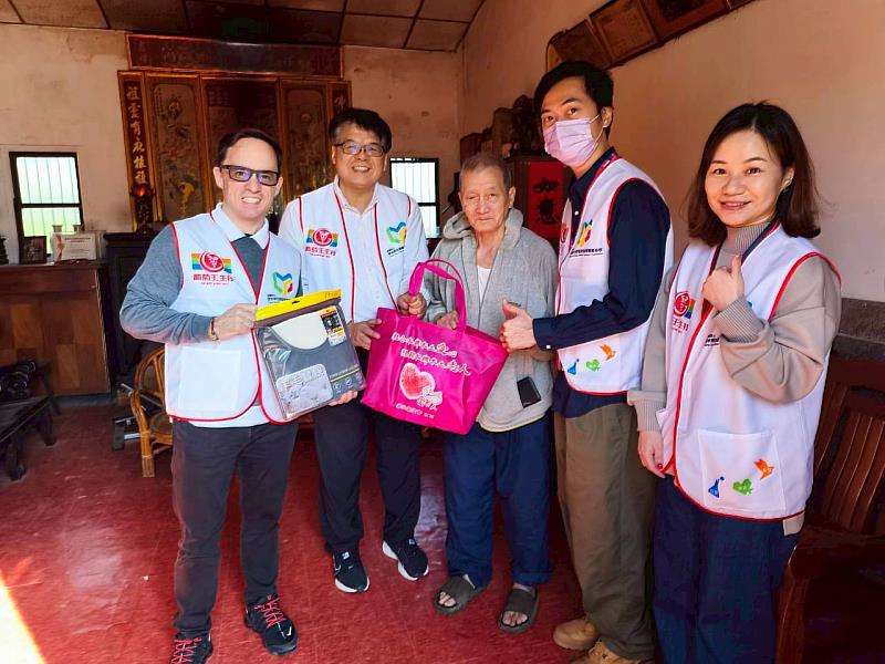 葡萄王生技志工隨同華山基金會至獨居長輩家中發送愛心年菜，並和爺爺在三合院裡話家常。
