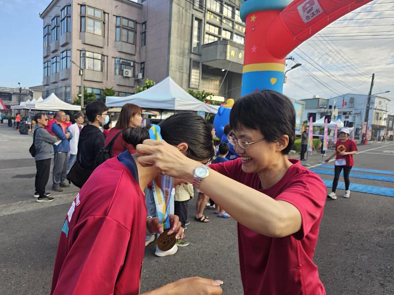 古秀妃主委為完賽選手掛上獎牌。